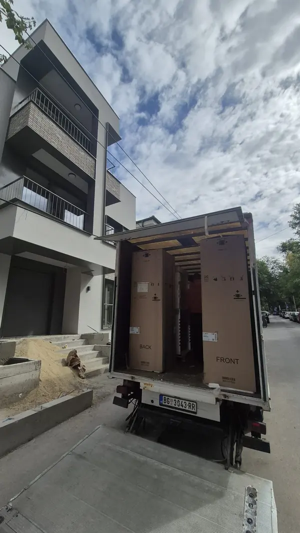 Selidbe stanova Vračar: kamion sa spuštenom rampom ispred nove zgrade, frižideri u kutijama