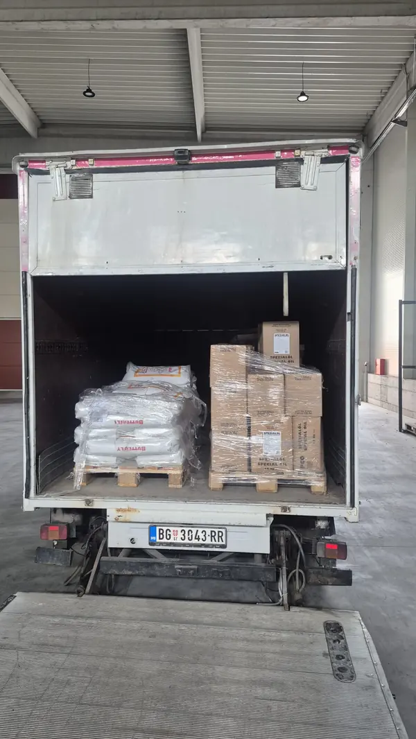 Transport paleta Čukarica: dve palete sa džakovima i kutijama u vozilu sa rampom, u magacinu