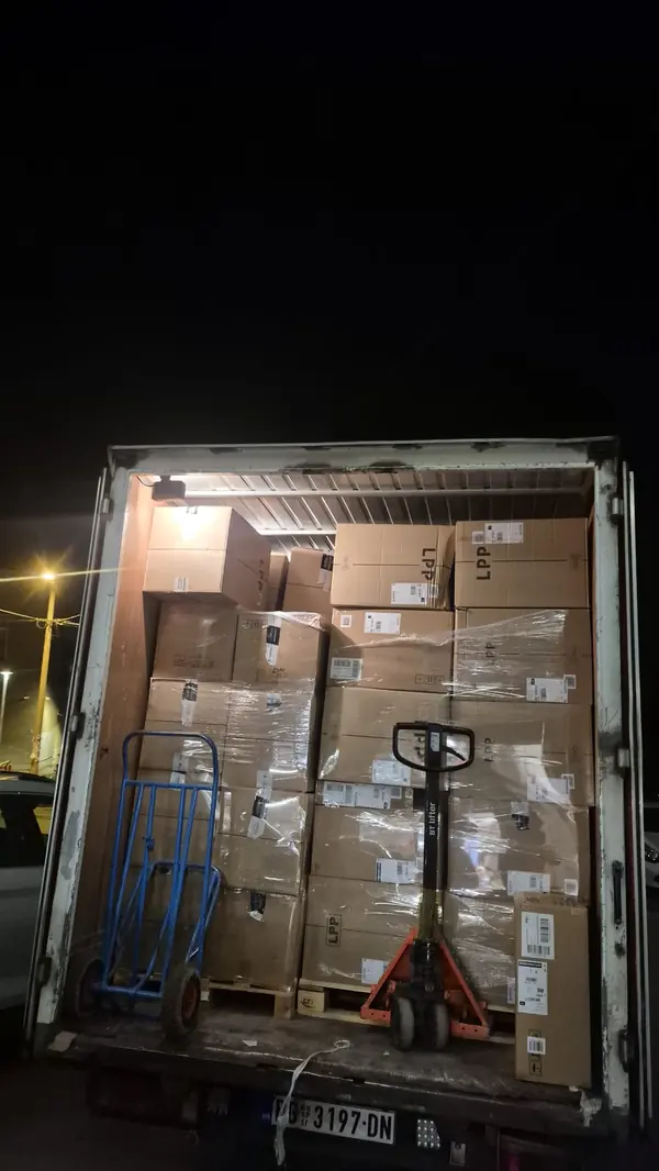 Transport robe Palilula: pun tovarni prostor sa kutijama na paletama, noću